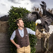 Musiker Kunz posiert mit einem Weisskopfseeadler im Greifvogelpark Buchs SG. Den ­gefiederten Tieren hat er das Lied «Vögu» gewidmet.