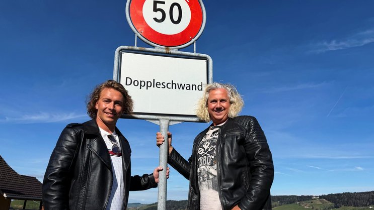 Martin Schwar­zentruber (l.) und Christian Duss zeigen sich stolz mit der Ortstafel ihrer Heimat­gemeinde.