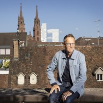 Das Basler Münster und die Roche-Türme im Hintergrund: ­Kabarettist Bänz Friedli vor den Wahrzeichen seiner Wahl­heimat Basel.