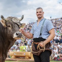 Der Ostschweizer Schwinger Samuel Giger und der kolossale Siegermuni Ultimo lassen sich vom begeisterten Publikum feiern.