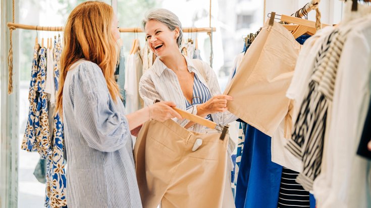 Fashionable middle-aged women shopping for clothes in a fashion boutique.