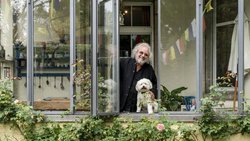 Harfenist Andreas Vollenweider geniesst mit Hund Henry den Rosengarten des Hilfswerks Rokpa in Zürich.